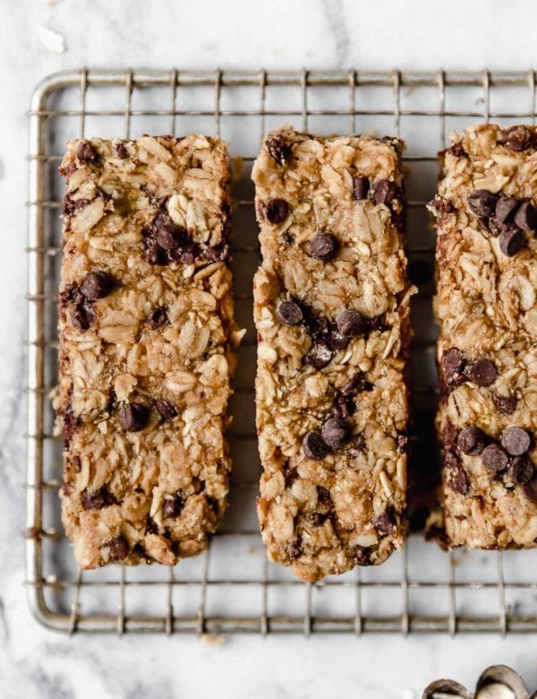 Three homemade granola bars cut into long bars on cooling rack