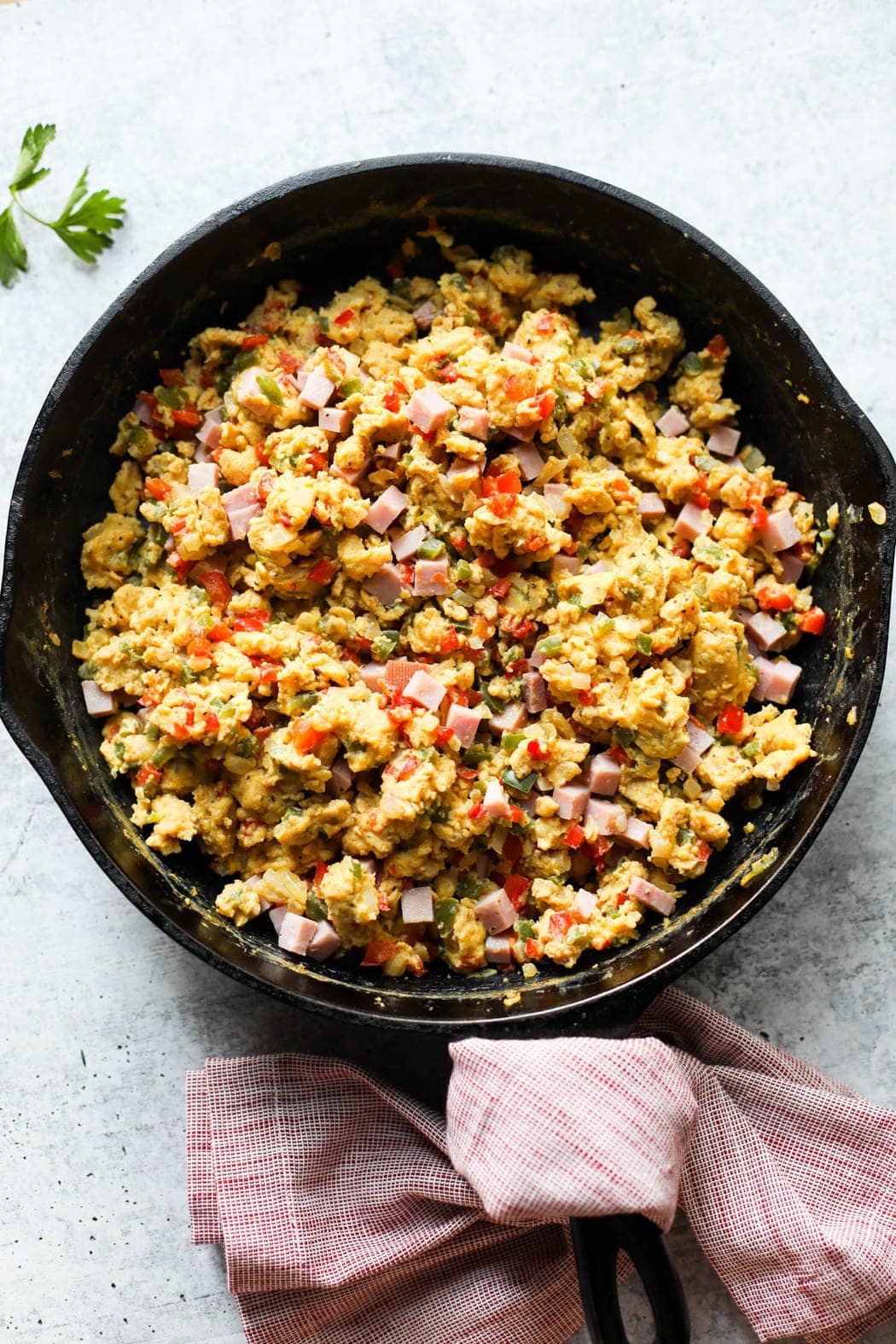 The scrambled egg and ham mixture for freezer burritos in a cast iron skillet