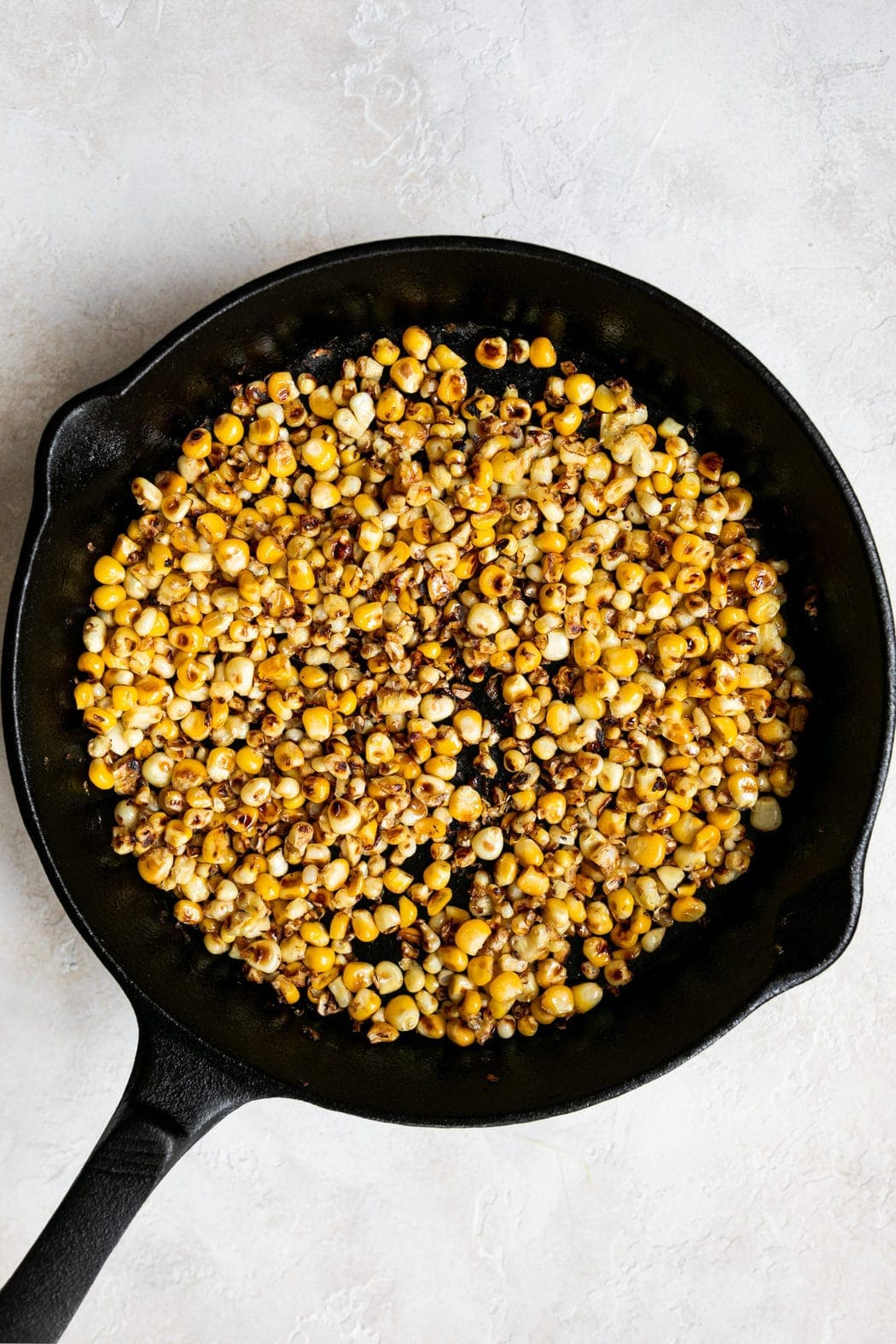 Sweet corn kernels in a cast iron skillet with slightly charred sides