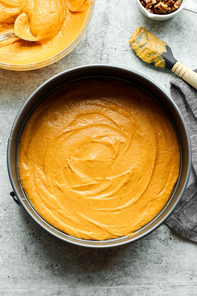 Pumpkin coffee cake batter spread out smoothly in bottom of round cake pan