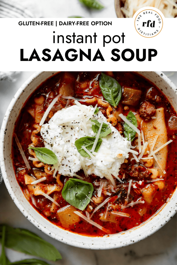 Instant Pot Lasagna Soup made with gluten-free lasagna noodles, ground beef, zucchini, and tomato basil marinara sauce in a speckled ceramic bowl topped with ricotta cheese and parmesan cheese.