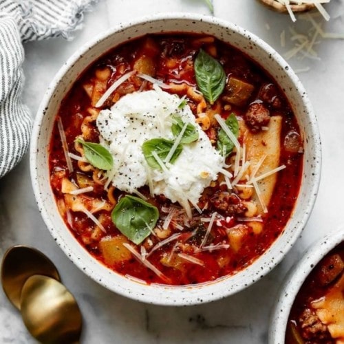 Instant Pot Lasagna Soup in a ceramic bowl topped with ricotta and fresh basil