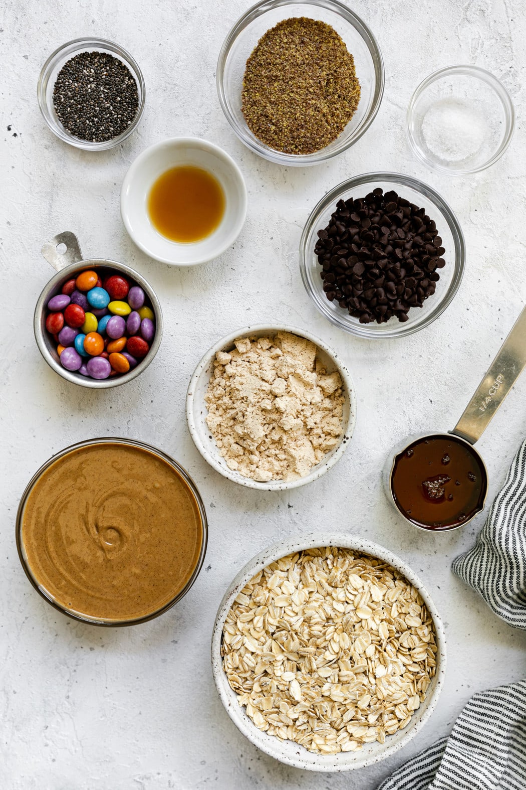 All ingredients for peanut butter protein balls arranged together in small bowls. 