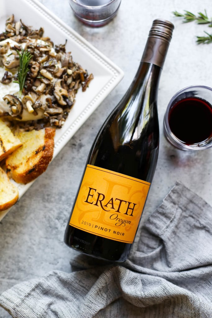 A tray of burrata toast to one side of a bottle or Erath Oregan Pinot Noir wine.
