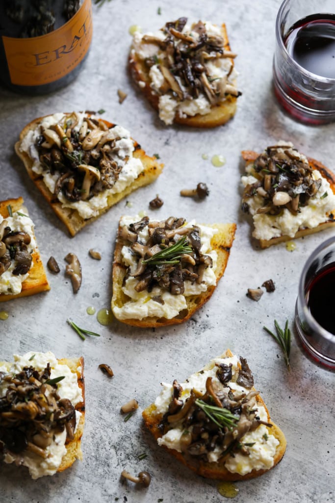 Several half slices of sourdough bread, toasted and topped with a creamy burrata cheese and sautéed mushrooms with fresh rosemary. 