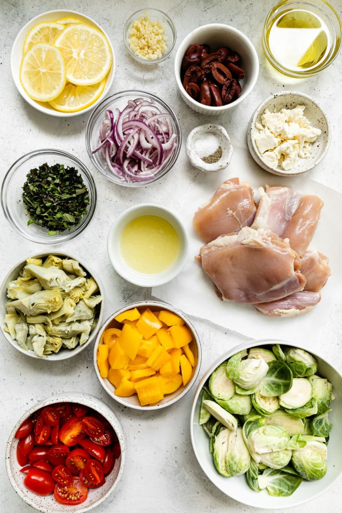 All ingredients for Greek Chicken and Veggies in small bowls arranged in a cluster.