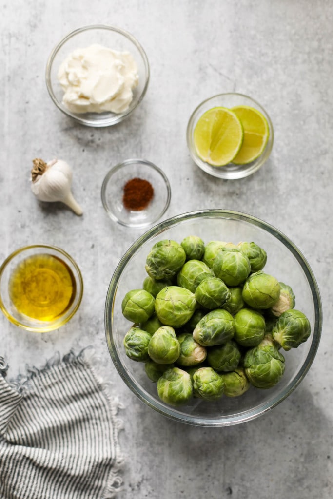 All ingredients for air fryer Brussels sprouts with aioli dipping sauce in small bowls