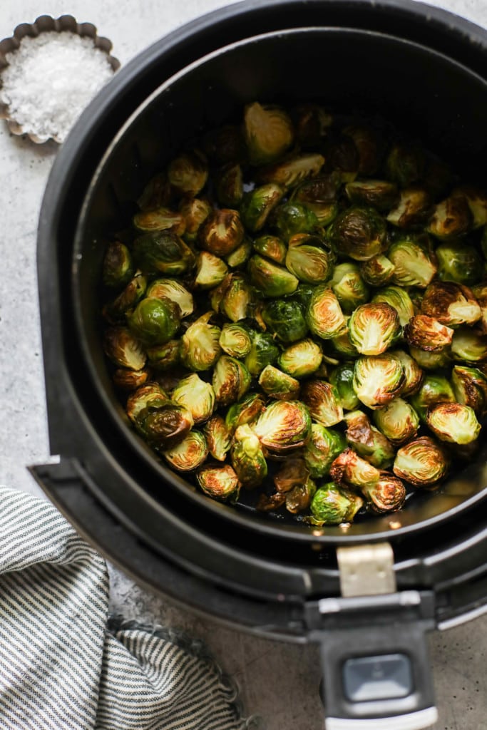 Crispy and golden brown air fried Brussels sprouts in an air fryer basket.