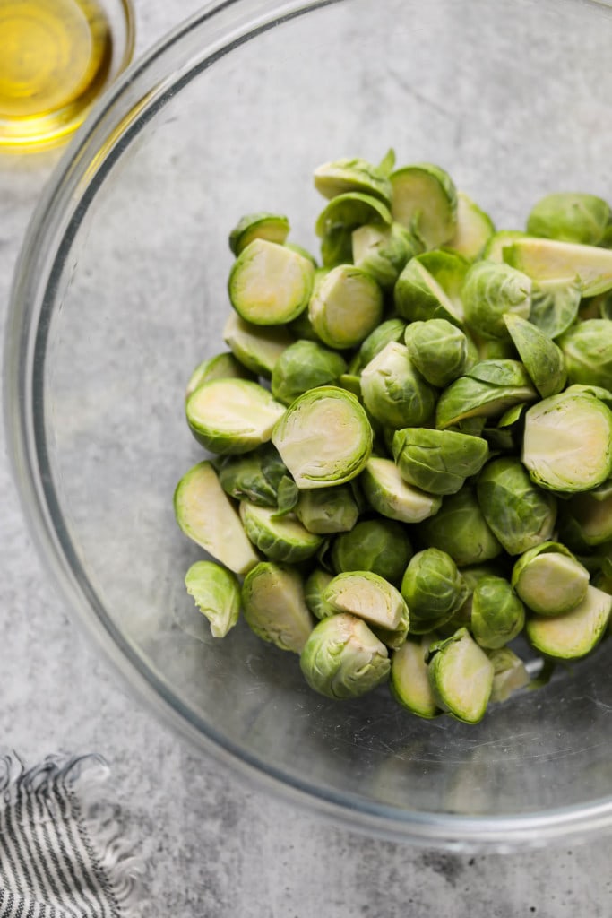 Brussels sprout halves in clear mixing bowl