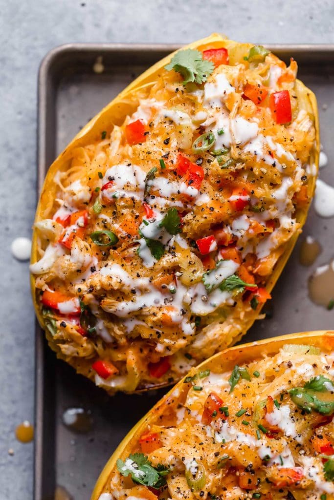 Close up view of buffalo chicken stuffed spaghetti squash topped with ranch dressing and blue cheese.