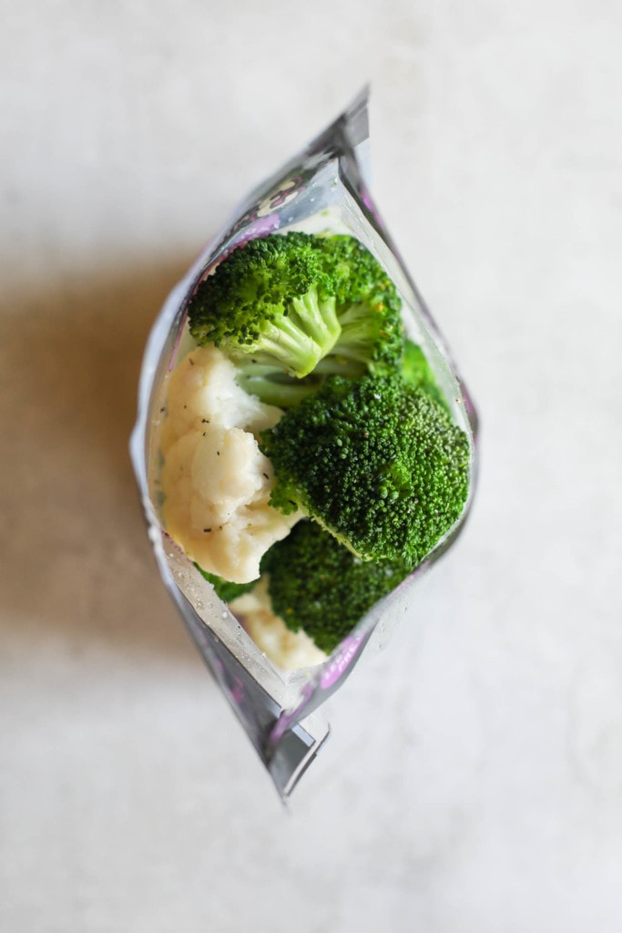 Overhead view of steamed broccoli and cauliflower florets in a bag