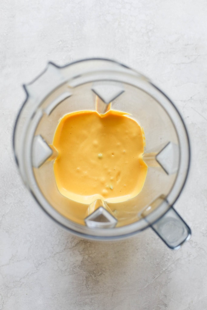 Overhead view of freshly blended dairy-free cheese sauce in a blender.