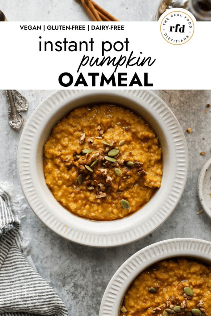 Overhead view of pumpkin oatmeal in a white bowl topped with maple syrup and pepitas.