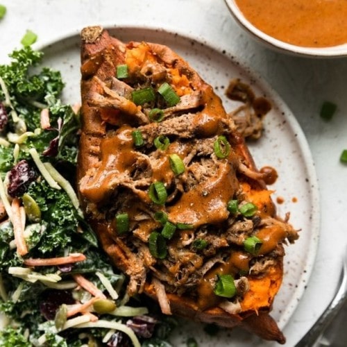 Honey mustard pulled pork in a baked sweet potato served with a kale side salad.