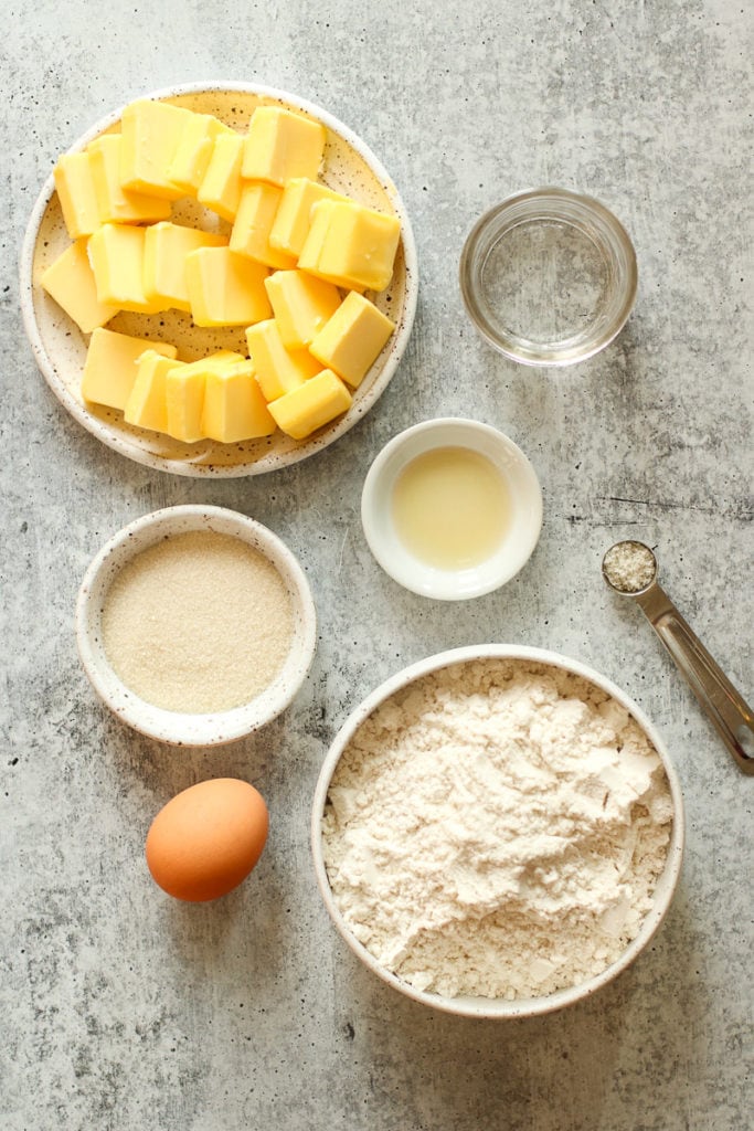 All ingredients for gluten-free pie crust in small bowls and measuring spoons. 