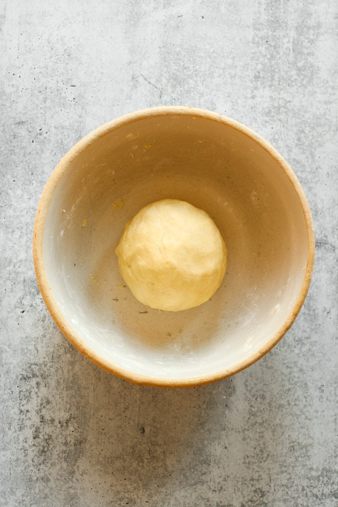 A pie crust dough ball in a mixing bowl