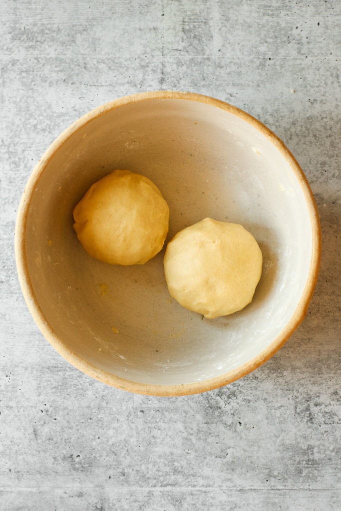 Two pie crust dough balls in a mixing bowl