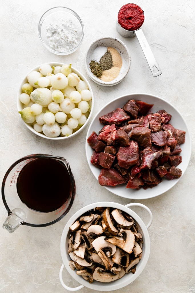 All ingredients for crockpot beef tips with gravy arranged together in small bowls and measuring cups.