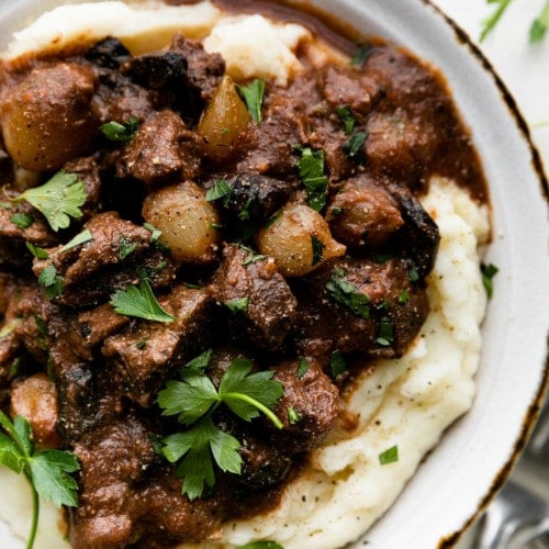 Slow cooker beef tips served over mashed potatoes with gravy