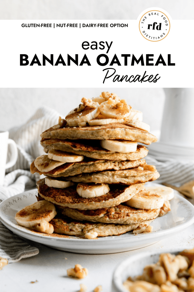 A stack of banana oatmeal pancakes with banana slices between the pancakes and topped with walnuts and cinnamon.