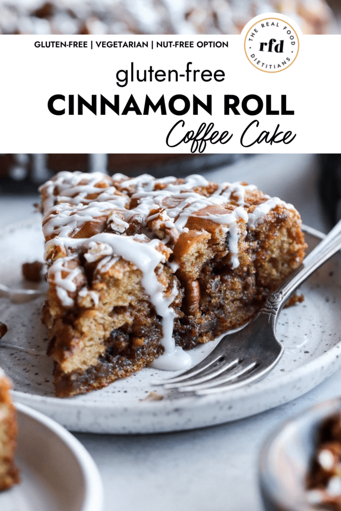 A slice of gluten-free cinnamon roll coffee cake with white drizzle and chopped pecans on a speckled plate with a fork.