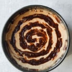 Overhead view round springform pan with cinnamon roll coffee cake batter with cinnamon swirl in circular patter on top. 