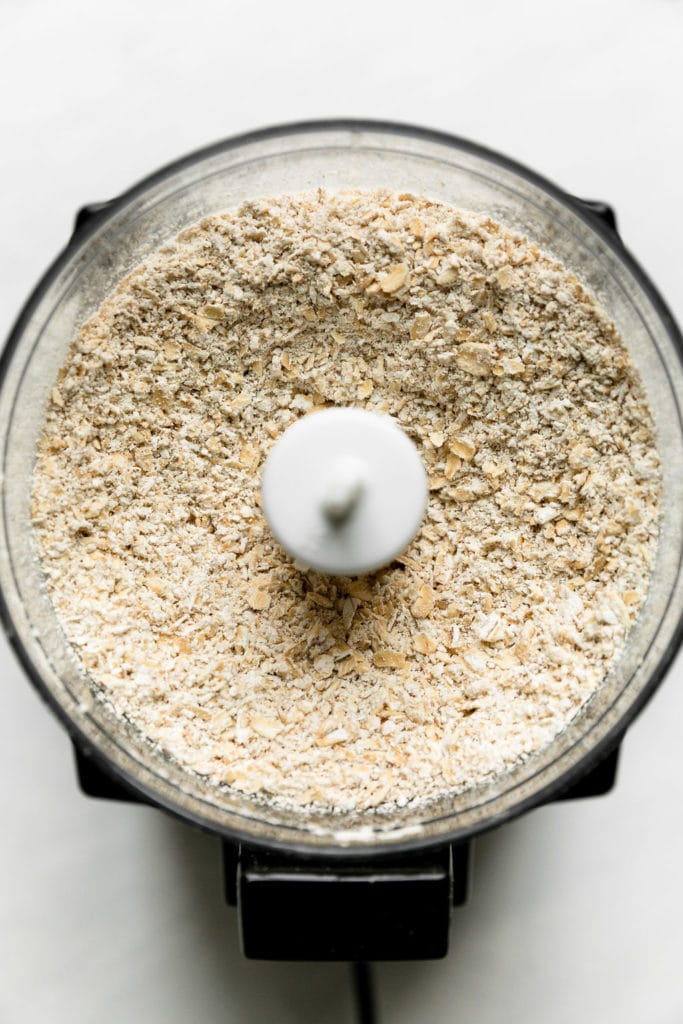 Overhead view of oats, coarsely ground in a food processor bowl