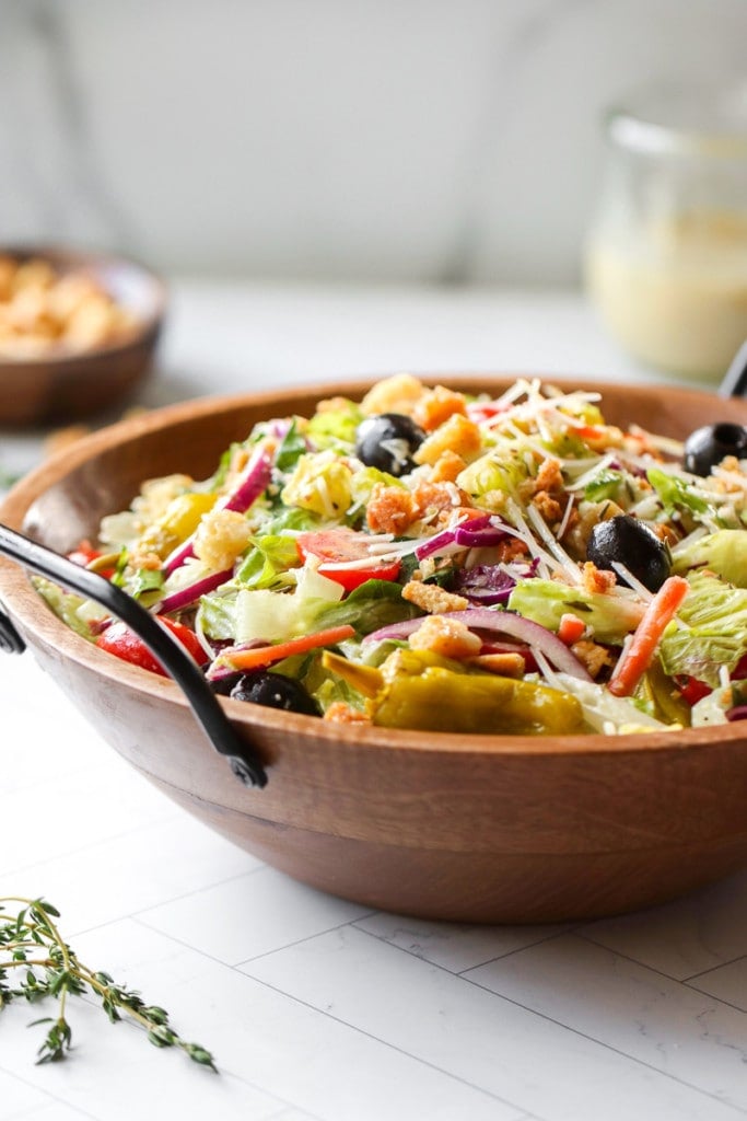 Copycat Olive Garden salad with creamy Italian Dressing and fresh veggies in a wooden serving bowl.