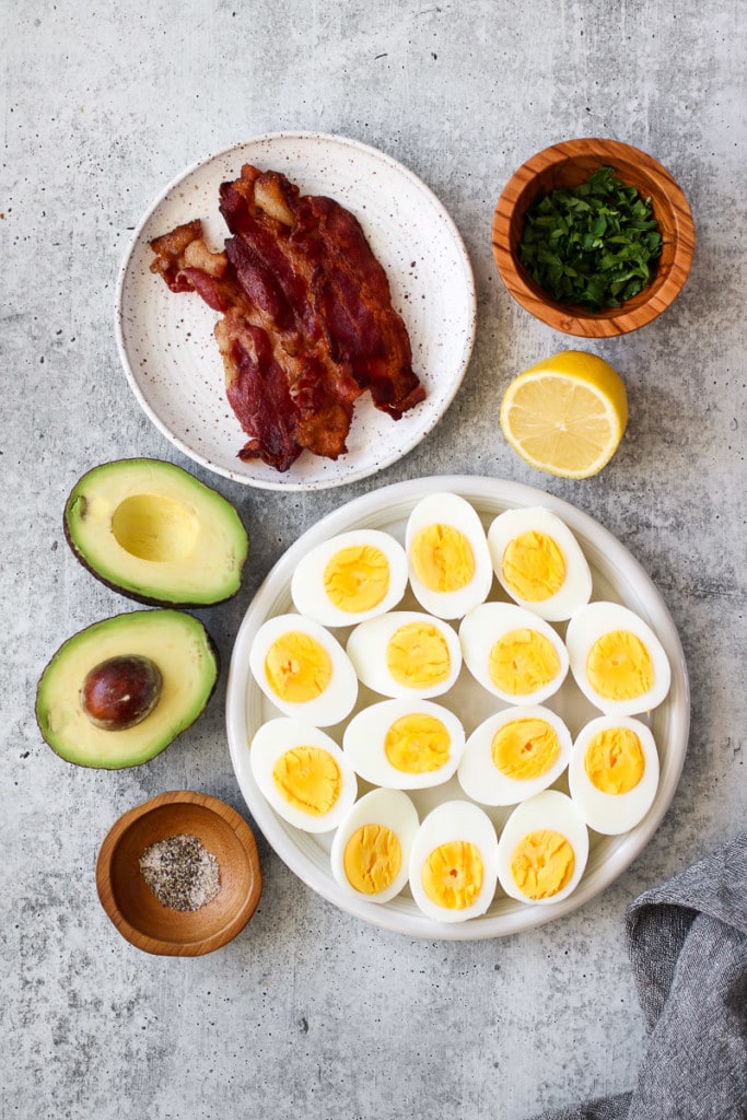 Overhead view of all ingredients for avocado deviled eggs with bacon.