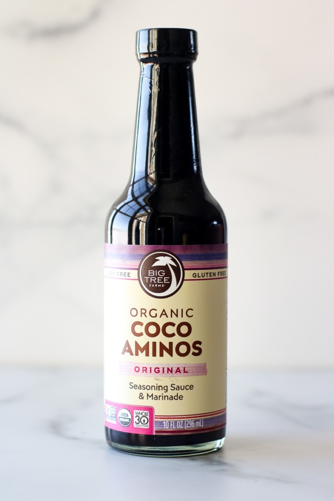 A glass bottle of Big Tree brand coconut aminos.