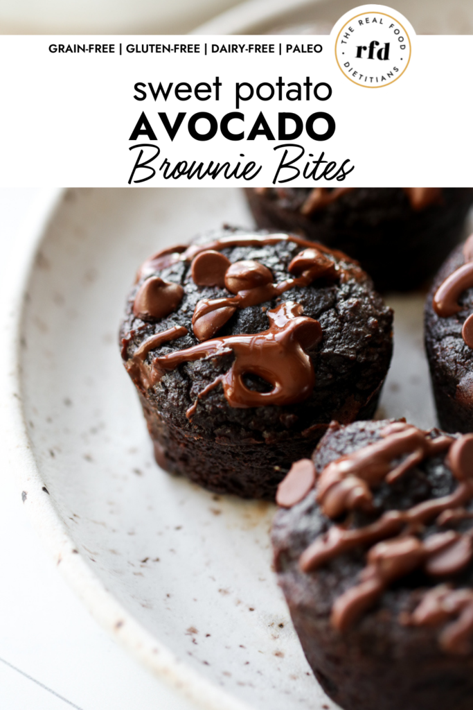 Close up view of a grain-free sweet potato avocado brownie bite topped with mini chocolate chips and chocolate drizzle, on a speckled plate.