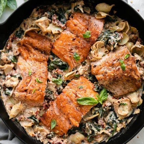 An overhead view of Tuscan salmon being cooked in a skillet.