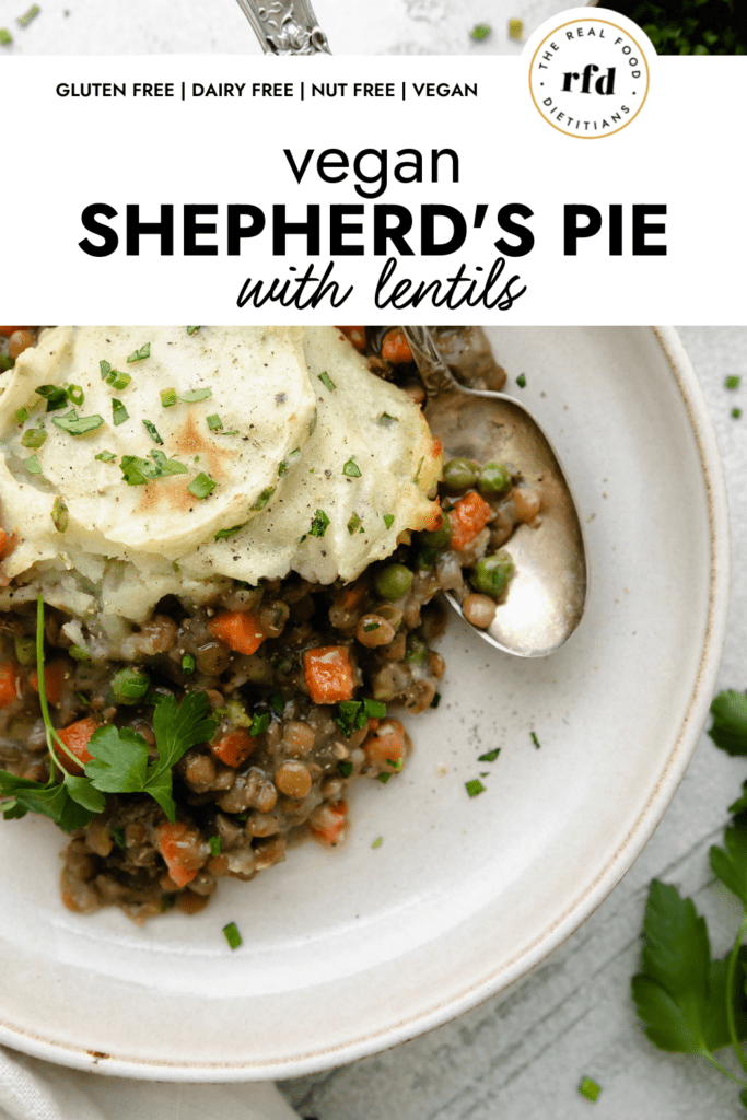 Overhead view of lentil shepherd's pie plated on a cream plate with creamy lentil filling and topped with baked mashed potatoes and fresh herbs.