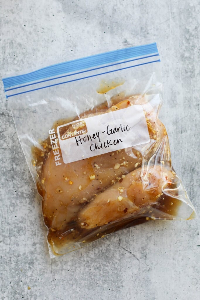 Overhead view of honey garlic chicken marinade in a ziplock bag with two chicken breasts. 