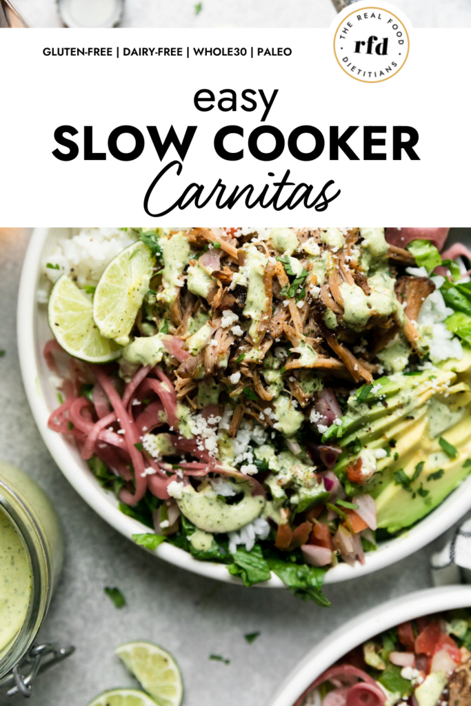 A white bowl filled with carnitas burrito bowl with white rice, slow cooker carnitas, pink pickled onions, avocado slices, and drizzled with cilantro-lime crema.