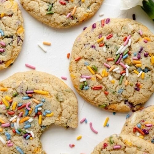 Overhead view of several gluten free funfetti cookies with rainbow sprinkles on a white background