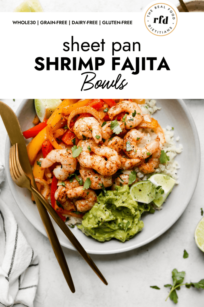 Overhead view of sheet pan shrimp fajita bowls served on a shallow bowl topped with pink shrimp and sprinkled with fresh cilantro.