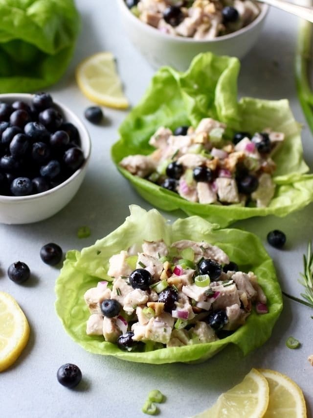 Two butter lettuce wraps filled with blueberry chicken salad with rosemary.