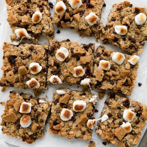 Overhead view of chewy s'mores granola bars cut into squares on parchment paper