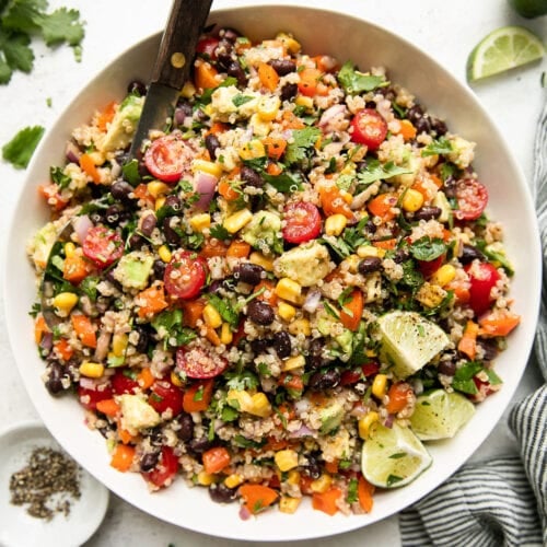 Overhead view Tex-Mex Quinoa Salad in white serving bowl with metal spoon