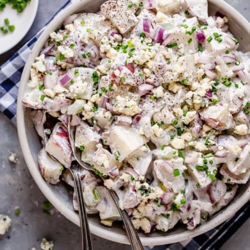 Overhead view blue cheese potato salad in white serving bowl.