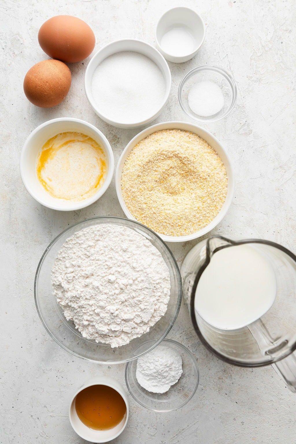 Overhead view of a variety of ingredients for Homemade Cornbread Muffins in different sized bowls.
