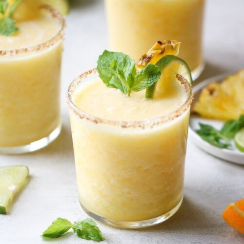 A short glass filled with frozen pineapple margarita