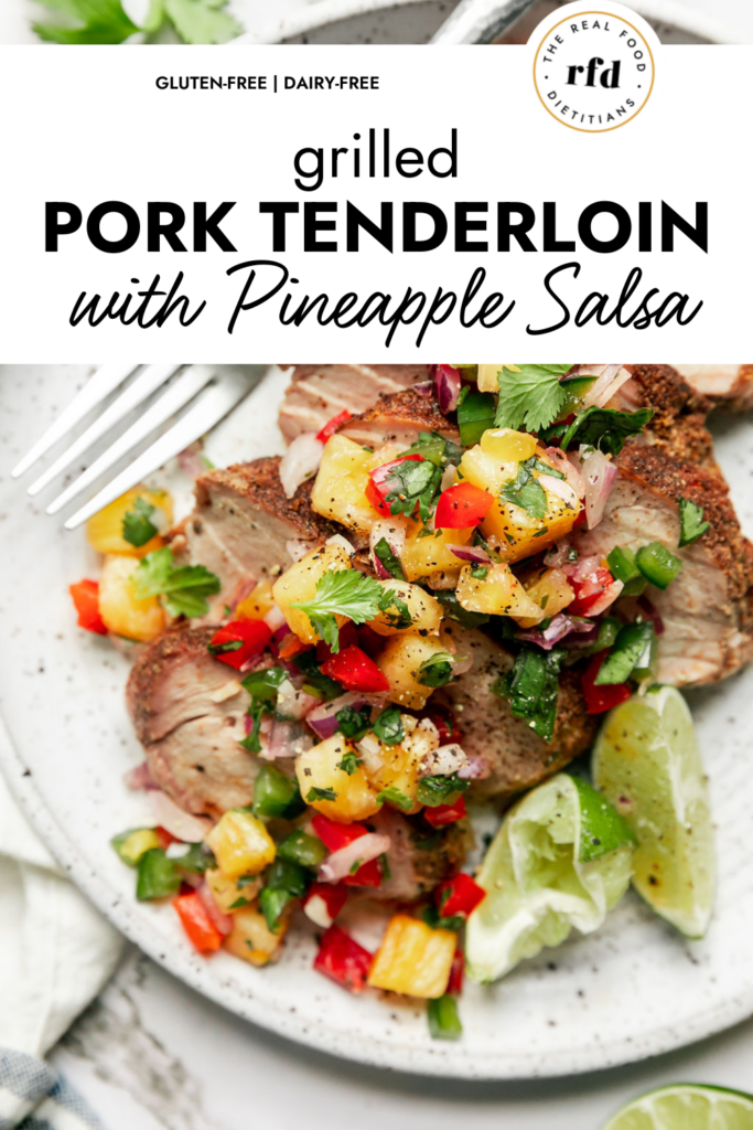 Grilled pork tenderloin slices on plate topped with pineapple salsa