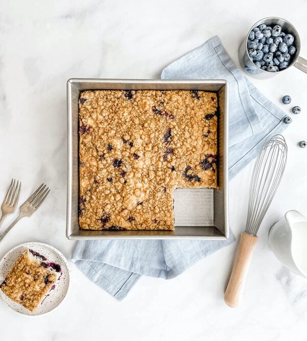 overhead shot of a 9x9 inch metal baking pan with blueberry baked oatmeal in it. One piece is missing.