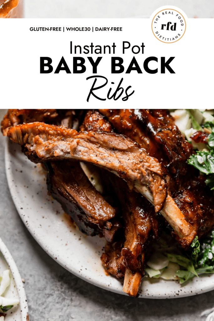 Close up view juicy bbq sauce covered instant pot baby back ribs on plate with kale salad on side. 