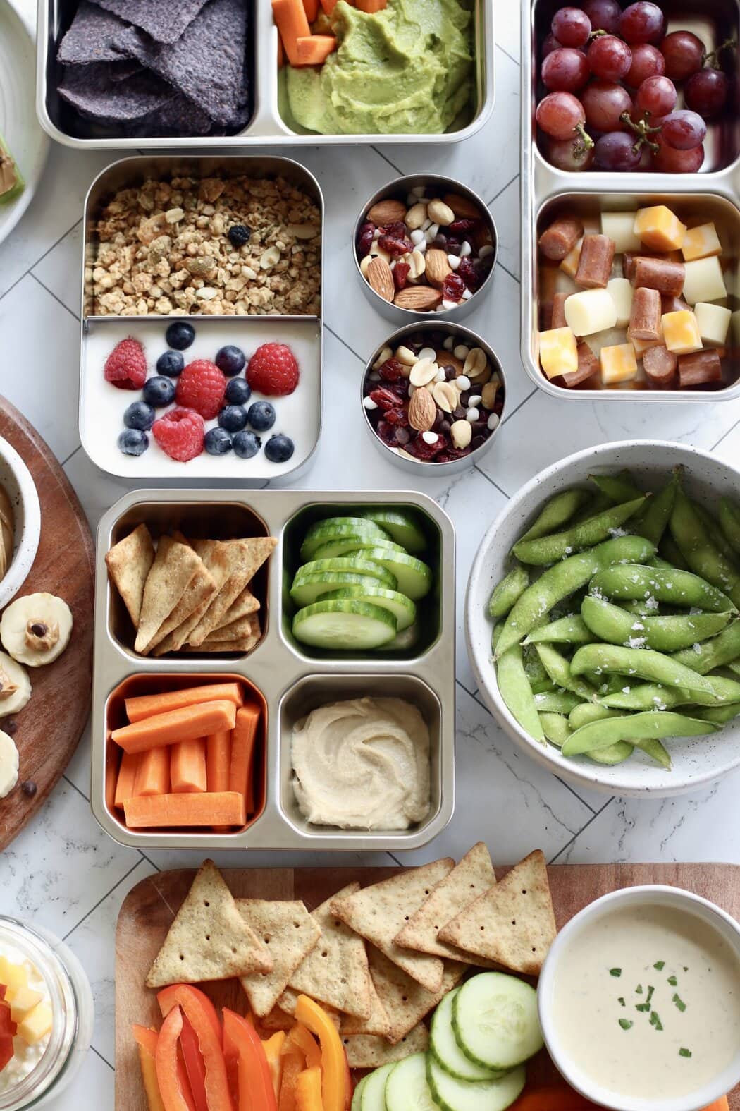 Overhead view of a colorful variety of snacks and lunches for children in different containers. 