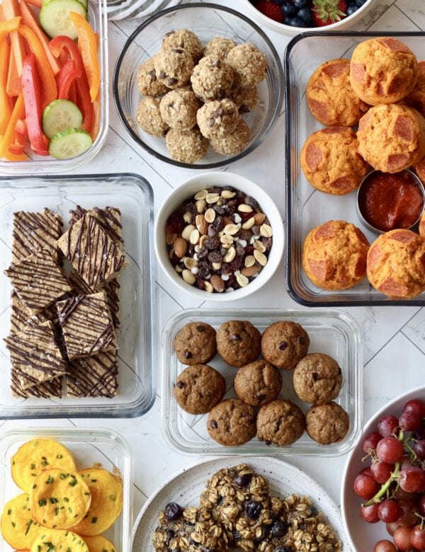 Overhead view several homemade snacks for kids in glass meal prep containers