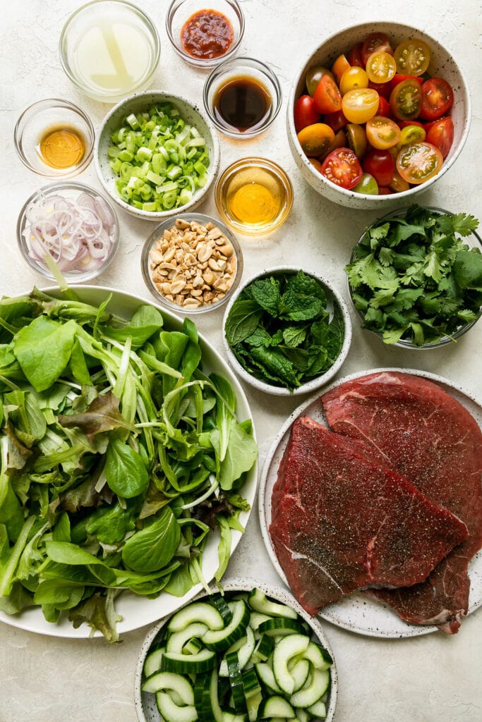 All ingredients for Thai-inspired Steak salad in bowls and plates. 