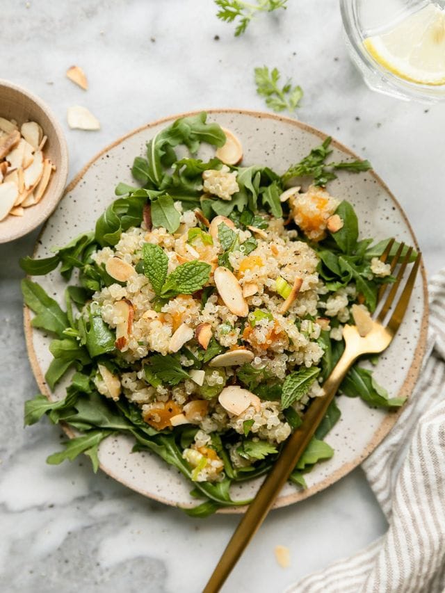 Overhead view herbed quinoa pilaf on stone plate.